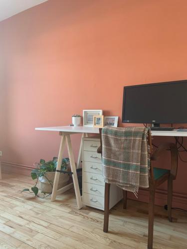 un bureau avec un écran d'ordinateur et une chaise dans l'établissement Joli appartement près du métro, à Villeurbanne