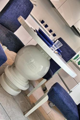 a white toilet in a room with blue chairs at Villa Maggie on Lake Como in Malgrate