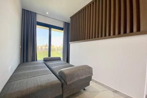 a bedroom with a bed and a large window at V luxury Suites in Pefkohori