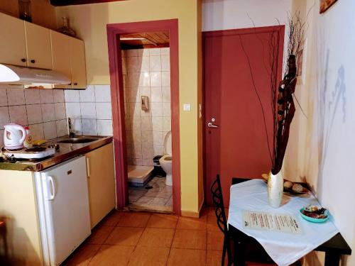 a kitchen with a table and a bathroom with a toilet at Caza Latina in Chania
