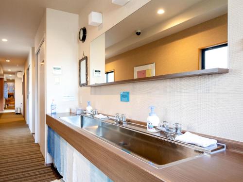 a bathroom with a sink and a mirror at Guest House Nakaima in Fukuoka