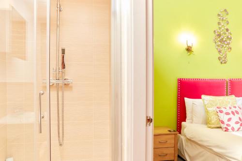 a bathroom with a shower and a bed and a tub at Finest Retreats - The Pig Barn in Ashbourne