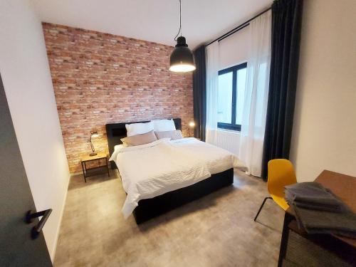 ブランデンブルク・アン・デア・ハーフェルにあるFerienwohnung Backstubeのベッドとレンガの壁がある寝室