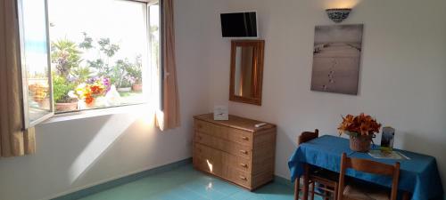 a room with a table and a dresser and a window at Casa Vacanze Elianto in Anzio