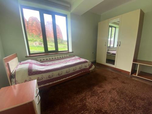 a bedroom with two beds and a large window at Emir in Dzhetyoguz