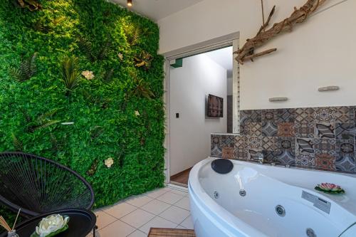 a bathroom with a green wall with a tub at Kentia Modern/Artistic City Apartment in Heraklio Town