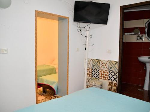a bedroom with a mirror and a bed and a television at Vitrage Guest House in Nazareth