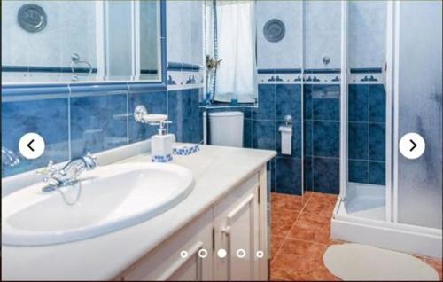 a blue bathroom with a sink and a shower at HIDALMAR in Arcos de la Frontera