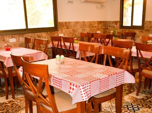 a restaurant with red and white tables and chairs at Vitrage Guest House in Nazareth