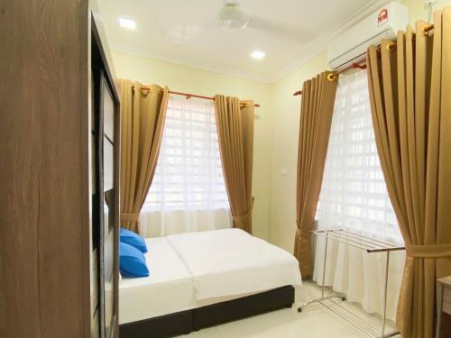 a bedroom with a bed and a window with curtains at NAZZA Homestay Besut with Swimming Pool in Kampung Raja