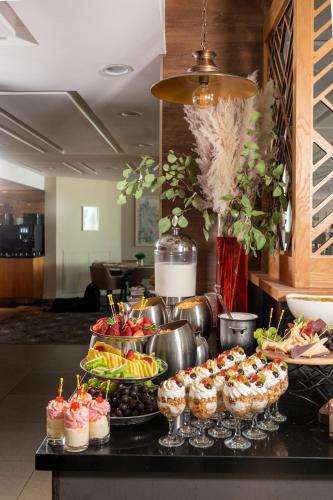 a buffet with cupcakes and other desserts on a table at Cassia Hotel Jerusalem in Jerusalem