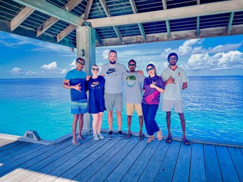 a group of people standing on a dock on the water at Sabba Beach Suite , Fodhdhoo - Maldives in Velidhoo