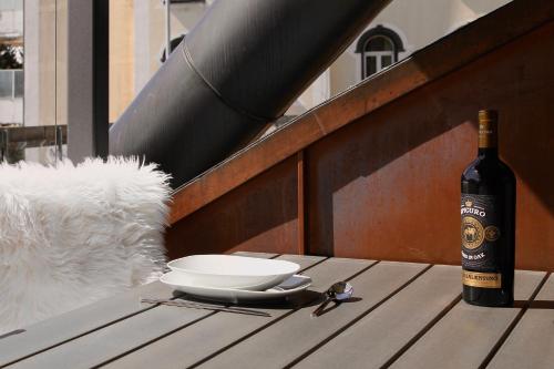 a bottle of wine sitting on a table next to a bowl and a bottle at Residenz Davos von Swisspartments in Davos
