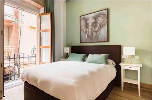 a bedroom with a large bed and a large window at Increíble Apto1º San Miguel-Centro-Catedral-Wifi-Parking in Granada