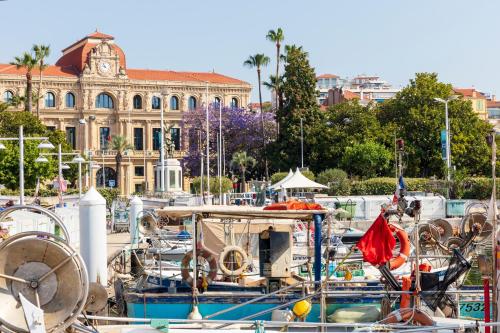 un groupe de bateaux garés dans une marina avec un bâtiment dans l'établissement Résidences Cresci, à Cannes