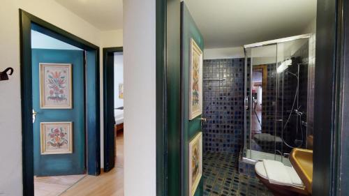een badkamer met blauwe muren en een glazen deur bij Rabgiusa 1 in Sils Maria