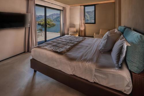 Un dormitorio con una cama grande con una ventana grande. en VILLA MOLLI Lago di Como, en Sala Comacina