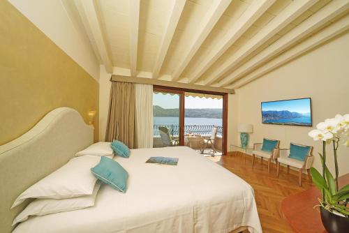 a bedroom with a large white bed with blue pillows at Hotel Vigna in Salò