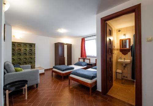 ein Wohnzimmer mit 2 Betten und einem Sofa in der Unterkunft Holló Panzió in Visegrád