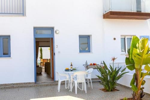 a white house with a table and chairs at Villa Nora in Protaras