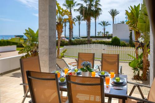 a table with a meal on a patio with palm trees at Villa Nora in Protaras