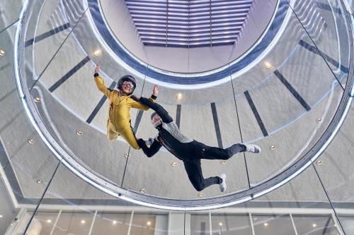a woman is jumping through a glass tunnel at Maison L'OCCITANE in Macau