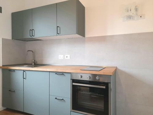 米蘭的住宿－Flat in Milano, Porta Romana，厨房配有白色橱柜、水槽和烤箱。