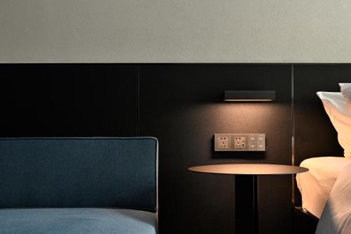 a room with a table and a bed and a table and a chair at LIA Hotel Shenzhen Qianhai Baoan Center Turnaround Metro Station in Bao'an