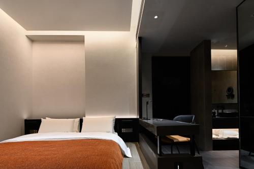 a bedroom with a bed and a desk at LIA Hotel Shenzhen Qianhai Baoan Center Turnaround Metro Station in Bao'an