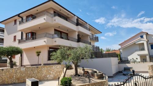 a house with balconies and a fence in front of it at Villa Vista 1 in Malinska
