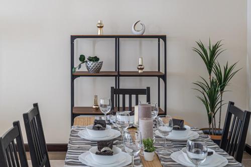 a dining room table with glasses and plates on it at HiGuests - Large Apt in the Heart of Deira Near Clocktower in Dubai