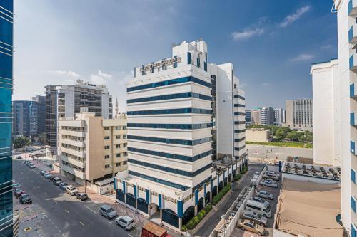 an aerial view of a tall white building in a city at HiGuests - Large Apt in the Heart of Deira Near Clocktower in Dubai