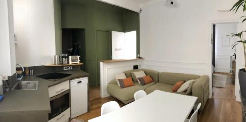 un salon avec un canapé et une table dans l'établissement Paris charm suite authentique, quartier latin, 2/4 pers, à Paris
