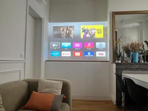 un salon avec un canapé et une télévision sur un mur dans l'établissement Paris charm suite authentique, quartier latin, 2/4 pers, à Paris