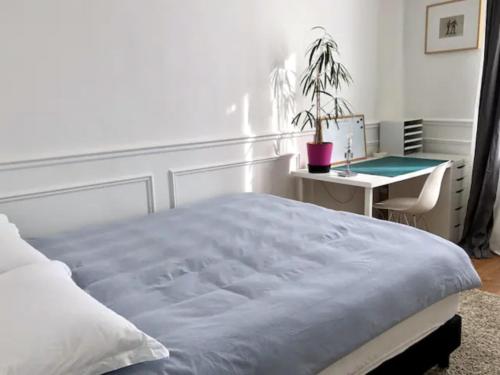 - une chambre avec un lit et un bureau avec une plante en pot dans l'établissement Paris charm suite authentique, quartier latin, 2/4 pers, à Paris