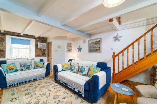 a living room with two chairs and a couch at Curlew Cottage in Uny Lelant