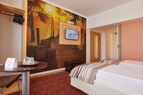 a hotel room with a bed and a table at MyContinental Bucuresti Gara de Nord in Bucharest