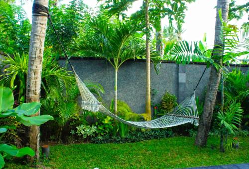 
a lawn chair sits in front of a fence at Mango Tree Villas in Jimbaran
