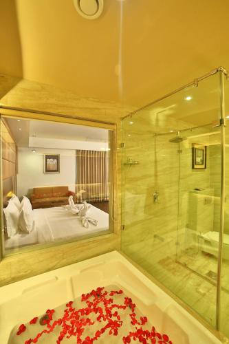 a bathroom with a shower and a bed and a tub at HOTEL G EXPRESS Formerly Known as TGB Express in Ahmedabad