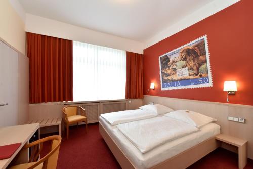a hotel room with a large bed and a large window at Hotel ADRIA München in Munich
