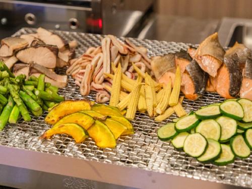 a grill with different types of food and vegetables at LiVEMAX RESORT Miyahama Ocean View in Hatsukaichi