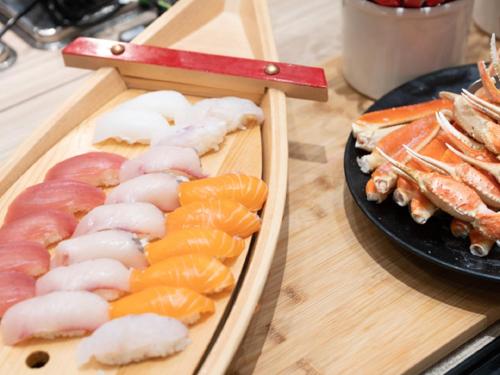 a display of sushi and seafood on a table at LiVEMAX RESORT Miyahama Ocean View in Hatsukaichi