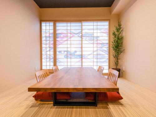 a large wooden table in a room with a large window at LiVEMAX RESORT Miyahama Ocean View in Hatsukaichi