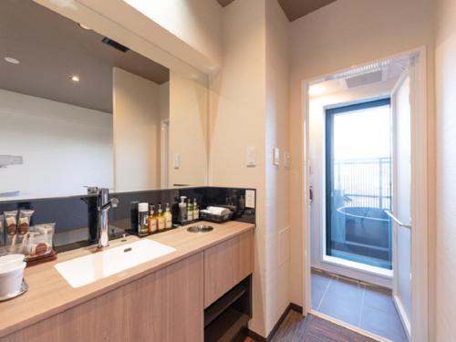 a bathroom with a sink and a large window at LiVEMAX RESORT Miyahama Ocean View in Hatsukaichi