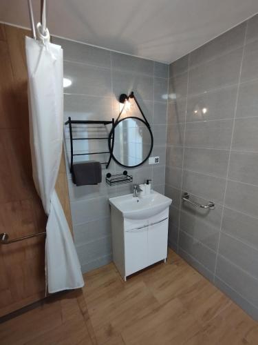 a bathroom with a sink and a mirror at Stodoły Hołosanka 600-065-145 in Polańczyk