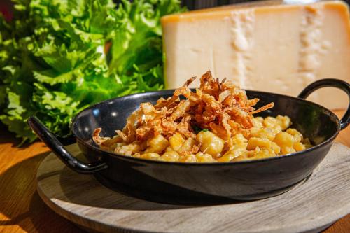 a black bowl of food on a plate with food at Voralpenhotel Schmoller in Sankt Georgen im Attergau