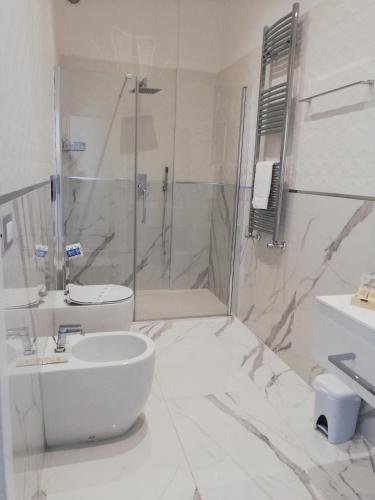 a bathroom with a shower and a toilet and a sink at Hotel Presidente in Porto Cesareo