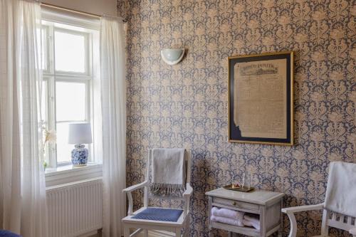 a room with a chair and a picture on the wall at Rosenhill Bed & Breakfast in Grebbestad
