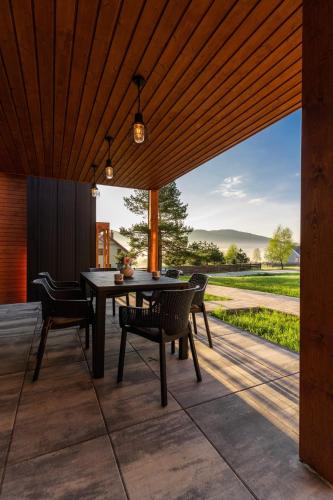 a dining room with a table and chairs on a patio at Wysowa Dwór in Wysowa-Zdrój