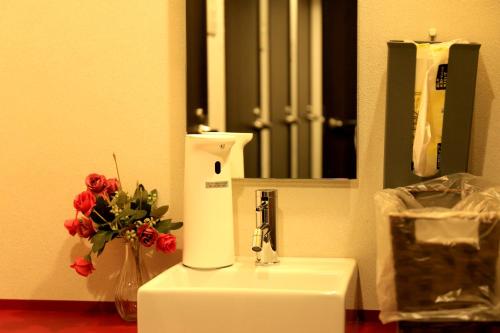 a bathroom with a sink with a vase of flowers at Setouchi Mangetsuso in Takamatsu